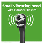 Close-up of a black toothbrush head with extra soft bristles and vibrating motion lines on green background