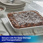 Baked chocolate dessert in a square aluminum foil pan with a clear plastic lid and plates in the background