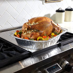 EZ Foil aluminum roaster pan with a stuffed roasted turkey and vegetables sitting on a stovetop.