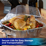 Cooked whole chicken in an aluminum roasting pan with a clear plastic lid set ajar on a kitchen counter