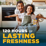 Smiling adult and child in a laundry room with a basket of clothes and a small Arm & Hammer Clean Scentsations bottle visible