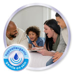 family smiling together on a bed with a circular badge reading hypoallergenic gentle on skin