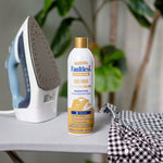 Faultless Premium Luxe Finish spray can on an ironing board next to an iron and a checked shirt in a lifestyle setting