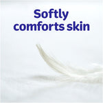 Close-up feather resting on a soft white surface with the headline 'Softly comforts skin' in large purple type.