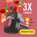 Close-up studio image of a Febreze AUTO vent clip with intensity dial and floating strawberries and blackberries