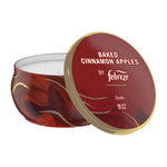 Red decorative tin candle with lid reading Baked Cinnamon Apples by Febreze shown on white background