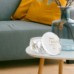 Febreze Ember marbled tin candle placed on a coffee table in a living room vignette with couch and vase
