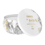 White-lidded Febreze Ember marble-pattern tin candle shown with lid leaning to reveal four wicks