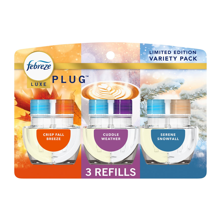 Febreze Luxe Plug refill variety pack showing three clear refill bottles labeled Crisp Fall Breeze, Cuddle Weather, Serene Snowfall on holiday-themed backing.