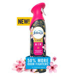 Pink-capped Febreze Luxe Air spray bottle with cherry blossom artwork and a 50% more odor fighters badge