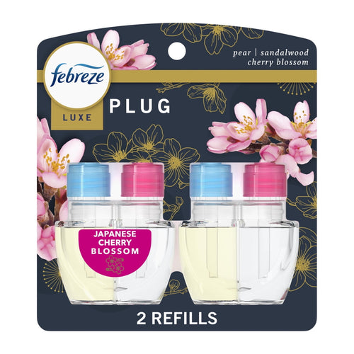 Retail blister pack showing two Febreze Luxe plug-in oil refills with cherry blossom graphics on dark background.