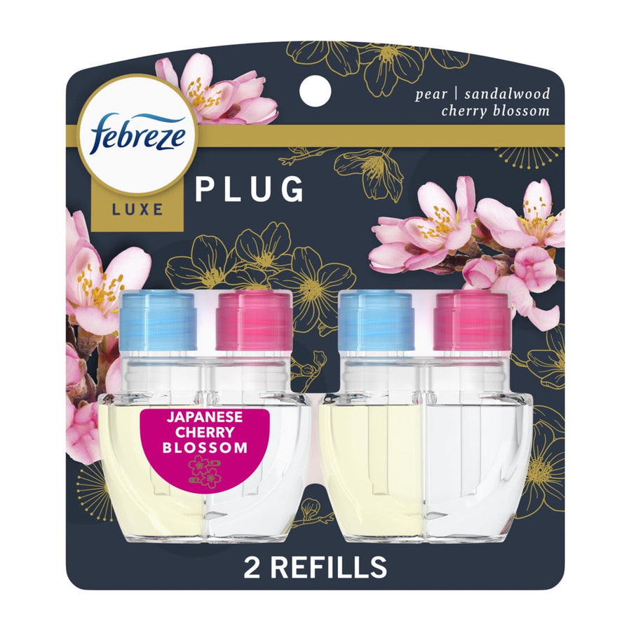 Retail blister pack showing two Febreze Luxe plug-in oil refills with cherry blossom graphics on dark background.
