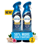 Two Febreze Luxe Ocean air mist spray bottles with promotional 50% more odor fighters banner and floral accents