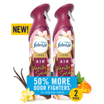 Two Febreze Luxe Vanilla Suede air mist cans with floral and vanilla visuals and a 50% more odor fighters banner