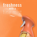 Close-up of Febreze spray nozzle emitting a fine mist on an orange background with text ‘freshness with a fine mist’