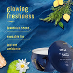 Promotional graphic with a Febreze Ocean candle tin and text listing features like 'glowing freshness' on a blue textured background.