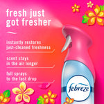 Close-up pink-capped Febreze spray bottle on a pink gradient background with benefits listed: restores freshness and longer-lasting scent.