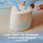 Top view of a Febreze Plug device with blue accent light and a finger pressing the 'boost' button, with promotional text below.
