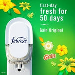 Febreze Plug unit plugged into an outlet on a green background with text “first-day fresh for 50 days” and Gain branding