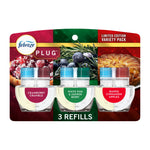 Packaged Febreze Plug refill trio showing three clear oil refill cartridges with labeled scent badges on holiday-themed backing card