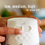 Close-up of a finger adjusting the Febreze Plug scent booster dial with text showing 'low, medium, high or even off!'.