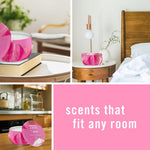 Collage of lifestyle shots showing the Febreze Romance & Desire pink candle tin placed around home surfaces with text ‘scents that fit any room’