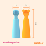 Graphic showing blue and orange silicone finger brush and tongue scraper with measurements: 1 inch widths and 3 inch height on a pale background.