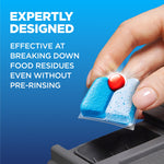 Hand placing a blue Finish Power detergent pod with red powerball into a dishwasher dispenser with text about breaking down food residues.