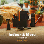 Lifestyle scene of Fiskars indoor gardening collection with watering can, toolbox and potted plants on textured rug