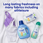 Flat-lay of athleisure garments with Snuggle +SuperFresh products including detergent, dryer sheets box, and spray