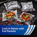 Four foil packets on a grill with colorful roasted vegetables visible in open packets.