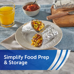 Two breakfast burritos wrapped partially in aluminum foil on a plate with orange juice and salsa, styled to show food wrapped in foil