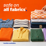 Folded clothing arranged in rows on an orange background with text stating 'safe on all fabrics' and a machine washables note
