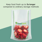 Clear FoodSaver stand-up vacuum bag half-filled with strawberries against a two-tone green background with freshness claim text