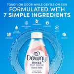 Downy Rinse Out Odor bottle centered inside a splash of water with icons and headline 'Formulated with 7 simple ingredients'