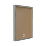 Rear view of a framed art piece showing wood frame edges and plain brown backing board with a small manufacturer label.
