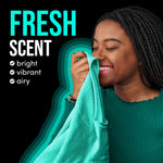 Smiling woman sniffing a teal shirt with text calling out ‘Fresh Scent’ and three scent attributes