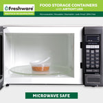 Clear Freshware container with lid inside a microwave on a glass turntable containing beans, graphic states microwave safe