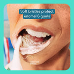 Close cropped shot of a person brushing teeth with foamy toothpaste and text callout about soft bristles protecting enamel and gums