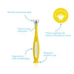 Yellow Frida Baby toothbrush shown upright with callouts highlighting triple-angle bristles and suction cup