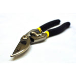 Angled view of a G & F bypass pruner with black handles and yellow accents resting on a white surface.