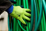 G & F glove wearing hand grabbing coiled green garden hoses, showing green back and navy foam palm