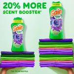Two Gain Moonlight Breeze scent booster bottles shown above stacks of folded clothes with text claiming 20% more scent booster