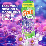 Gain scent booster bottle set against a purple floral background with text tagline and decorative flowers and water splashes