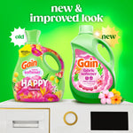 Comparison graphic showing old and new Gain fabric softener bottle designs on a bright green background with 'new & improved look' text