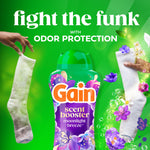 Gain scent booster bottle between two socks with copy 'fight the funk' and 'odor protection' on green background.