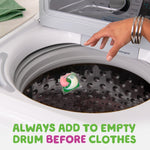 Top-load washing machine drum with a tricolored gain flings pac floating inside and a hand reaching toward it; usage text at bottom.