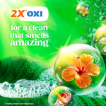 '2X OXI' themed promotional image with bubbles and a hibiscus flower emphasizing a fresh scent