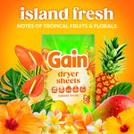 Gain Island Fresh dryer sheets box centered amid pineapple, mango and tropical flowers on orange background