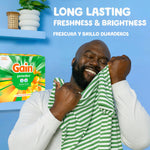 Smiling man holding a striped shirt to his face with Gain powder box and freshness text in background